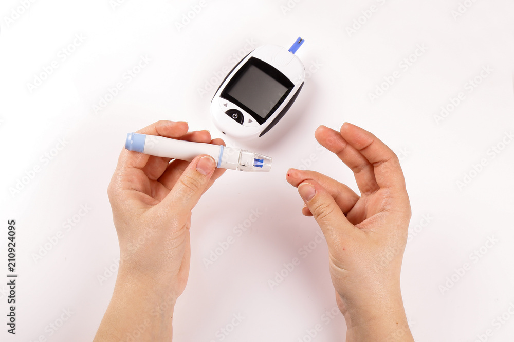 One person with diabetes doing a blood test with a glucometer isolated on white background One person with diabetes doing a blood test with a glucometer isolated on white background