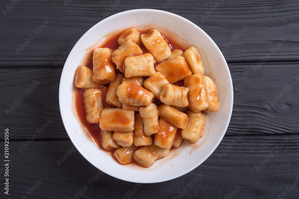 Homemade potatoes gnocchi with tomato sauce . Homemade potatoes gnocchi with tomato sauce .