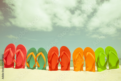 colorful flip flop on sandy beach  green sea and blue sky background for summer holiday and vacation concept.