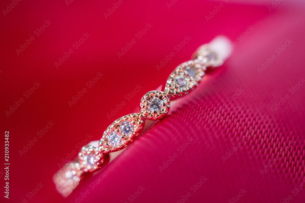 Jewelry luxury pink gold ring with sapphire gemstone on red fabric texture background Jewelry luxury pink gold ring with sapphire gemstone on red fabric texture background