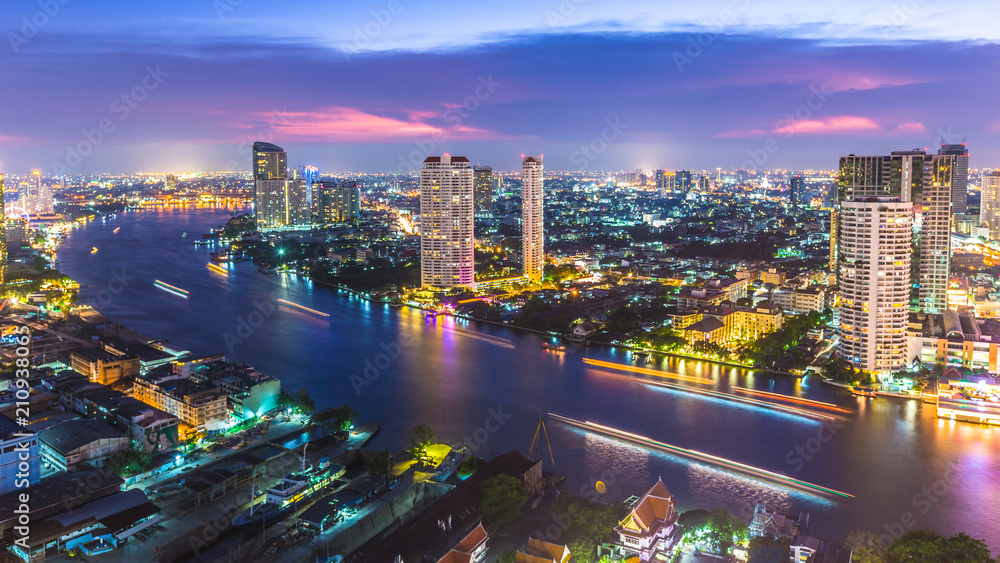 Fototapeta premium Aerial view of Bangkok City modern office buildings, condominium, hotel in Bangkok city downtown business and finance with Chao Phraya River during sunset sky, Bangkok, Thailand.