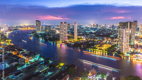 Aerial view of Bangkok City modern office buildings, condominium, hotel in Bangkok city downtown business and finance with Chao Phraya River during sunset sky, Bangkok, Thailand. photo