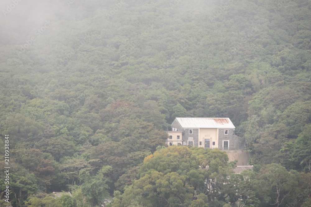 A traditional home on the hillside with fog around in HongKong A traditional home on the hillside with fog around in HongKong