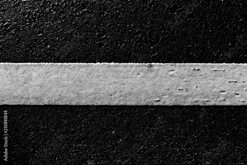 dirty white line on surface of old asphalt in countryside