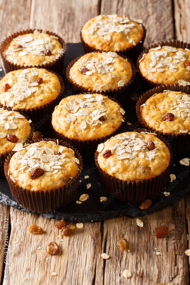 Homemade muffins of oatmeal with raisins close-up on the table. vertical, rustic style Homemade muffins of oatmeal with raisins close-up on the table. vertical, rustic style
