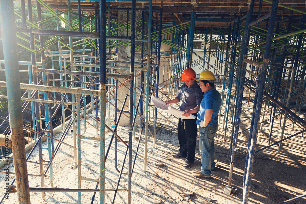 Construction concepts, Engineer and Architect working at Construction Site with blueprint Construction concepts, Engineer and Architect working at Construction Site with blueprint