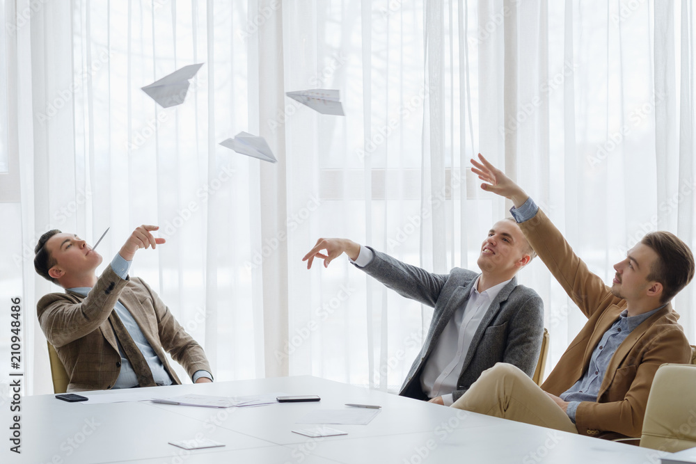 © golubovy - business men throwing paper planes at the board meeting. small break from work to relax. fun workday and office atmosphere © golubovy - business men throwing paper planes at the board meeting. small break from work to relax. fun workday and office atmosphere