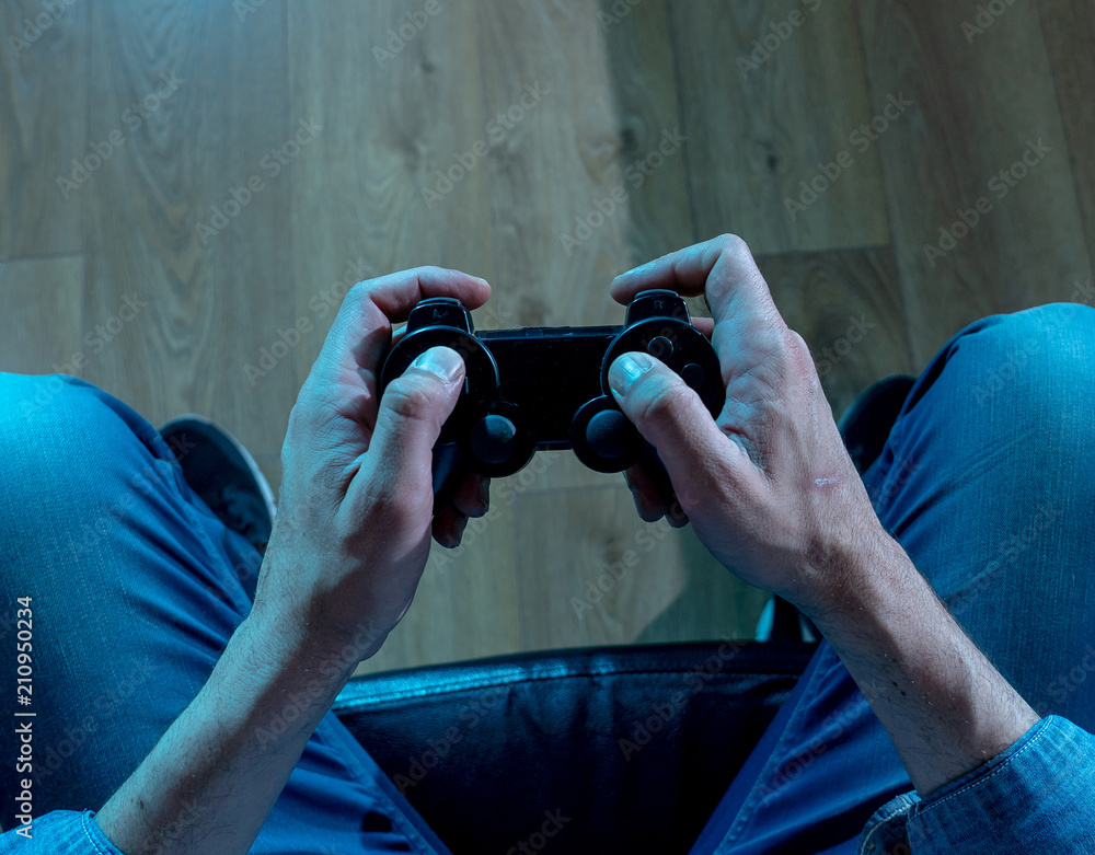 Naklejka premium close up of young mans hand holding a joystick in video game add