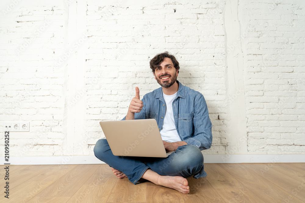 freelance hipster working from home on a laptop with white brick wall background. freelance hipster working from home on a laptop with white brick wall background.