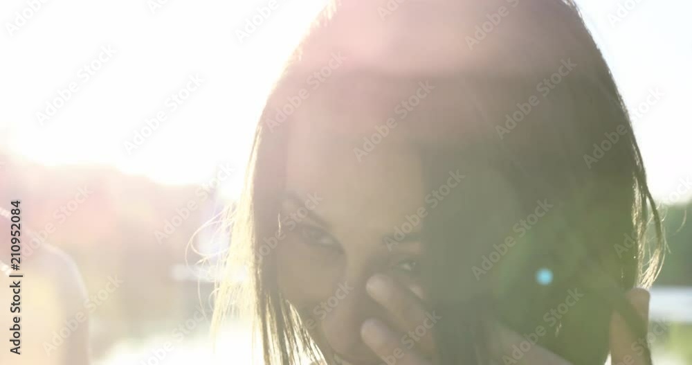 Young 20s woman outdoors in front of lake - crying laughing from joke - slow motion Young 20s woman outdoors in front of lake - crying laughing from joke - slow motion