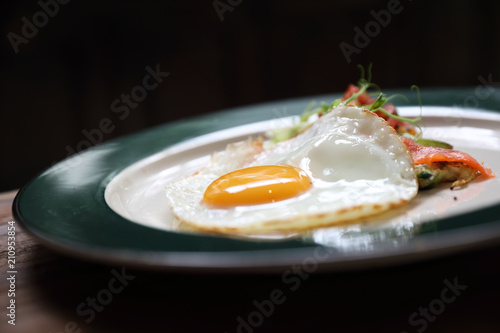 Zucchini fritters with egg and smoked salmon on wood background vinage style photo