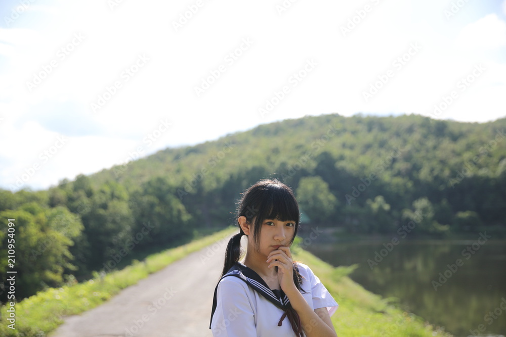 Naklejka premium Portrait of Asian Japanese school girl looking in country side background