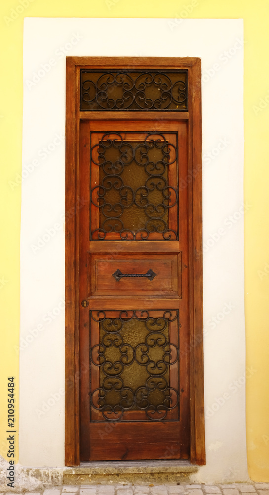 Old and aged historic door in ocher wood in the city of San Felice Circeo (seaside), Lazio, Italy