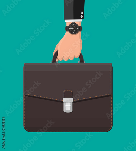Businessman with wrist watch and suitcase in hand