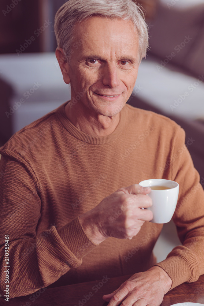 Deep on thoughts. Happy male person posing on camera while going to drink coffee Deep on thoughts. Happy male person posing on camera while going to drink coffee