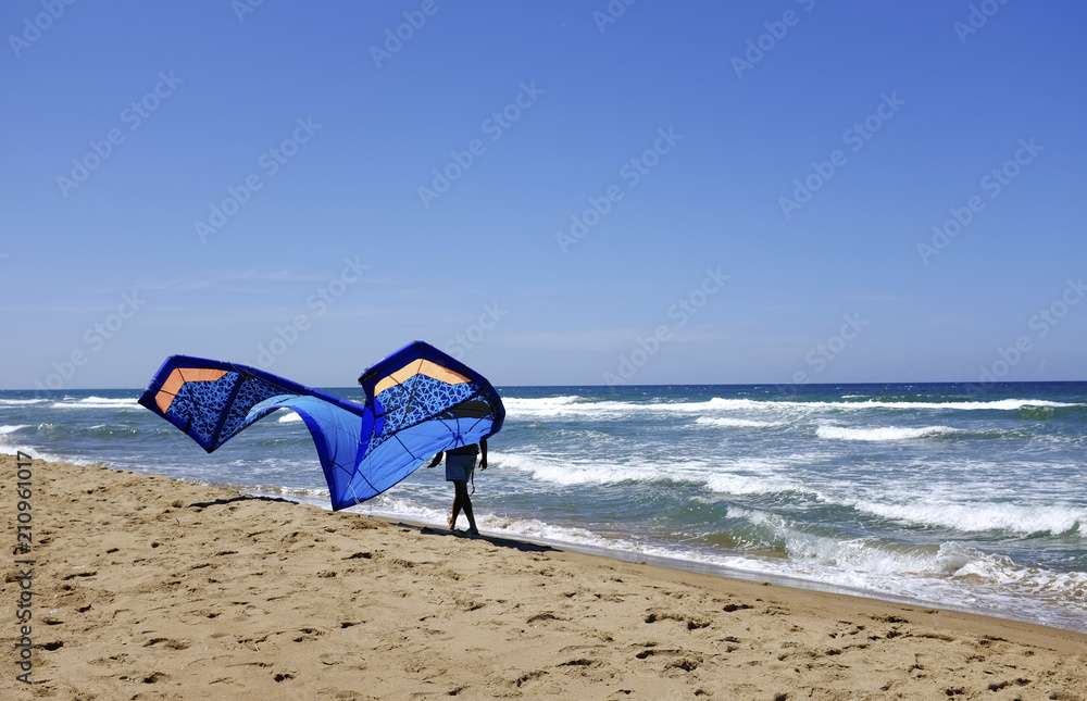 Man sufrers in wetsuits with kite equipment for surfing, in Sabaudia, Lazio, Italy Man sufrers in wetsuits with kite equipment for surfing, in Sabaudia, Lazio, Italy