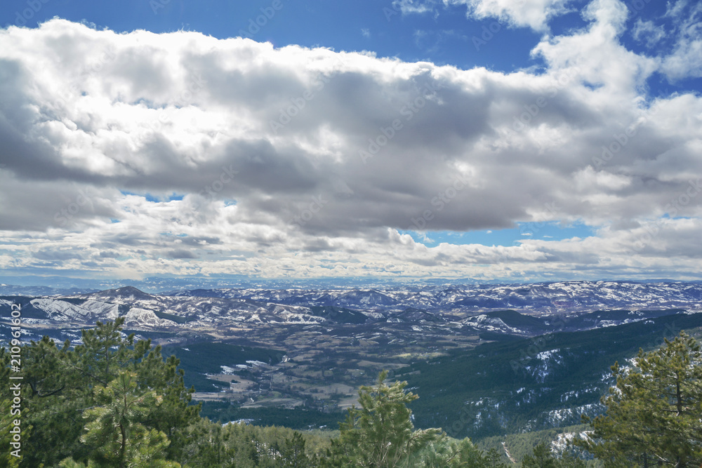 Fototapeta premium Mountain view valley on snow winter day with cloudy dark and blue sky