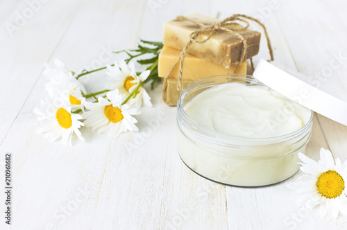 Natural cosmetics, handmade soaps, face and body cream with chamomile flower on a light background. Spa concept organic cosmetic. Natural beauty product. photo