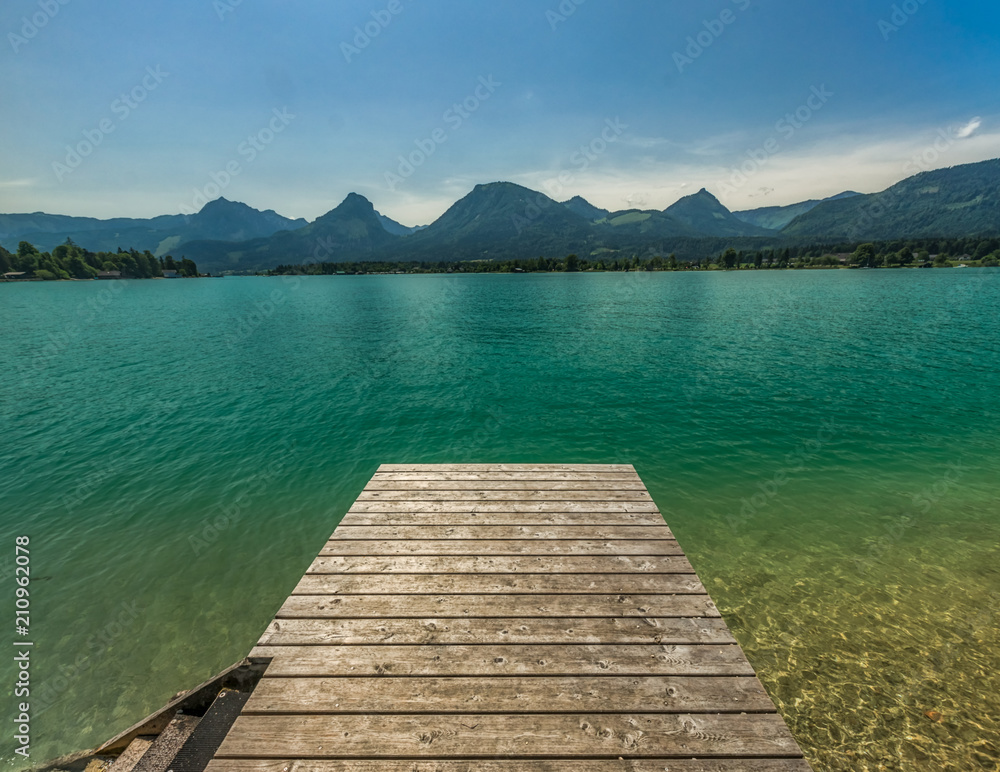 Sommer - ein menschenleerer Steg zu einem herrlichen Badesee mit türkisem, warmen Wasser, der Wolfgangsee in Österreich