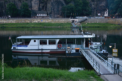 Schona, Germany - June 16, 2018: white ferry on european river Elbe in german village Schona in Saxon Switzerland at evening photo