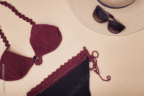 Burgundy swimsuit, hat and sunglasses. Beach wardrobe. Fashionable concept