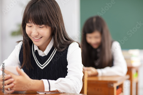 teenager girl watching the smart phone in classroom