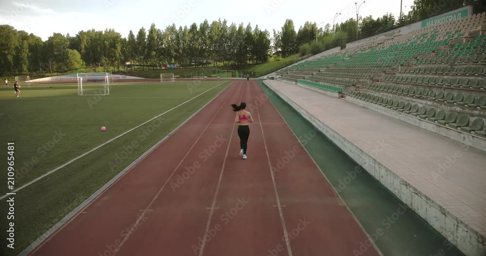 aerial. slim athletic girl jogging at the stadium. attractive young woman exercising outdoors aerial. slim athletic girl jogging at the stadium. attractive young woman exercising outdoors