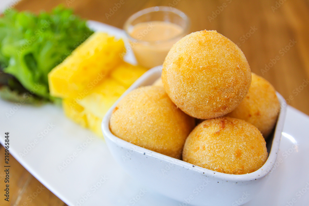 Fried cheese balls with pineapple ,lettuce and sauce.