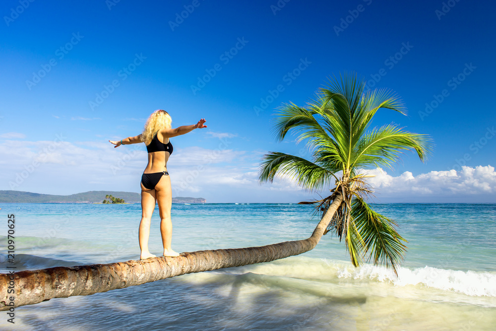 girl making steps on the palm tree - obrazy, fototapety, plakaty 