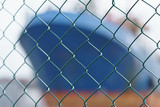 The image of the ship through the metal fence with bokeh defocused background