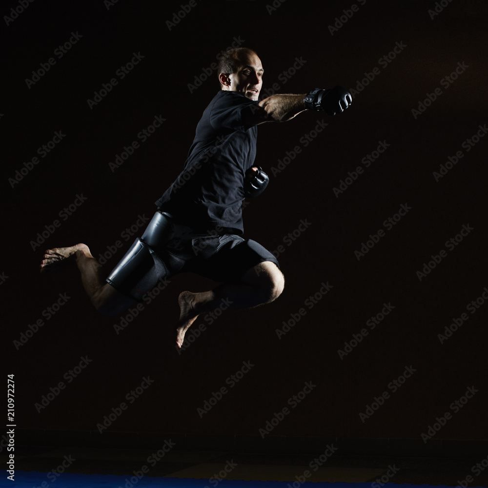A man in a black T-shirt beats with his hand in a jump