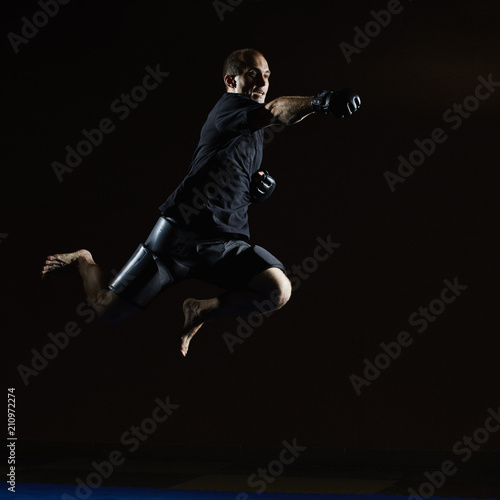 A man in a black T-shirt beats with his hand in a jump