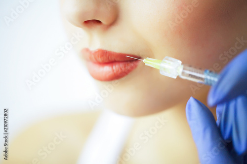 Beauty and Care. Portrait of a Young Woman with a Beautiful Face. A Cosmetologist Makes Injections. High Resolution