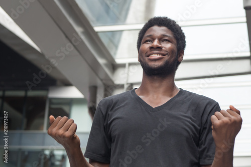 Strong successful African man portrait; happy smiling strong confident young adult african man expressing positive excited, surprised expression; African young adult man model