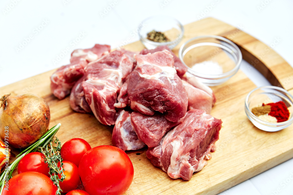 raw, fresh pork with vegetables, tomatoes onions