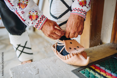 Man putting on traditional bulgarian leather shoes - Tsarvuli 