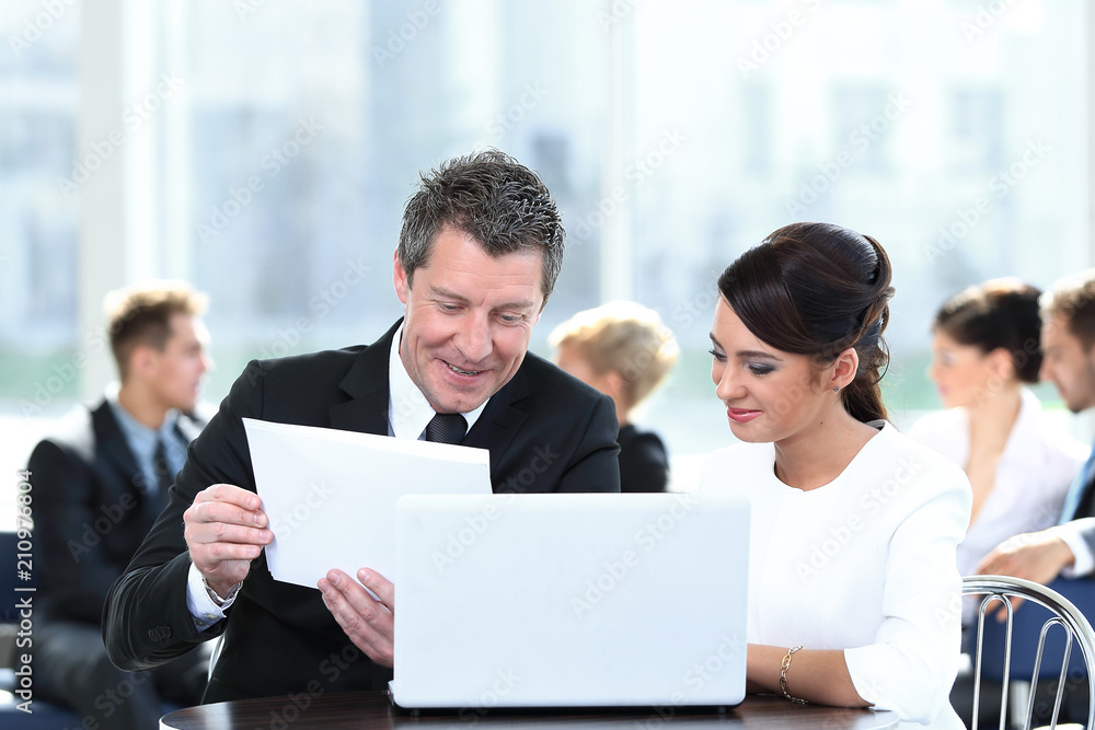 business partners discussing documents, sitting at the table. business partners discussing documents, sitting at the table.