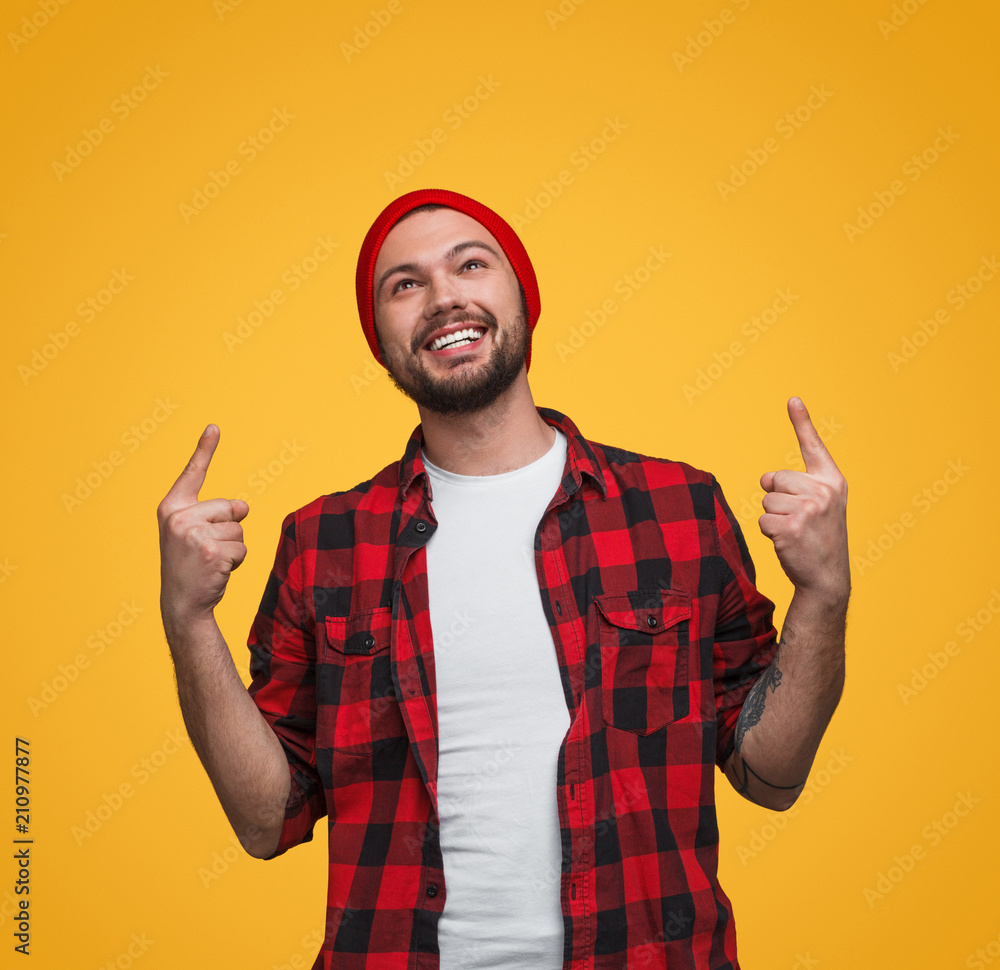 Naklejka premium Cheerful guy showing up with fingers
