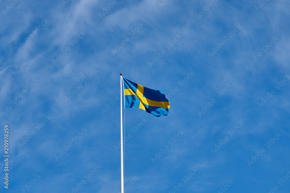 Flag of Sweden against a blue cloudy sky on a background. Flag of Sweden against a blue cloudy sky on a background.
