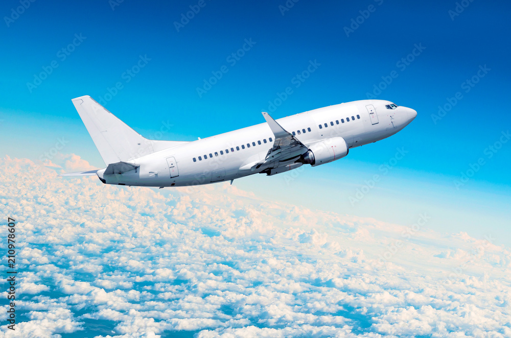 Obraz premium Passenger airplane fly on a hight above overcast clouds and blue sky.