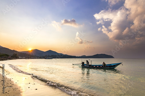 ocean seashore with palms and boat on water at sunset in Phangan island