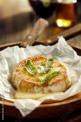 Grilled Camembert cheese with addition aromatic herbs, close up. Vegetarian food, barbecue, bbq.