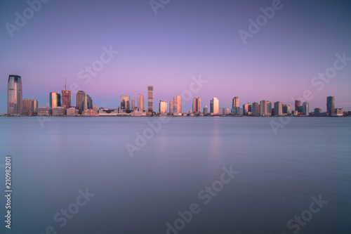 Canvas-taulu View on Jersey city from water during sunrise from
