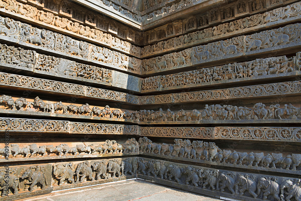 Friezes of animals, scenes from mythological episodes from Ramayana and Mahabharata, at the base of temple, Hoysaleshwara temple, Halebidu, Karnataka. View from South.