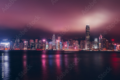 Hong Kong skyline on Victoria Harbour with moody mist and clouds in sky © Tom Eversley