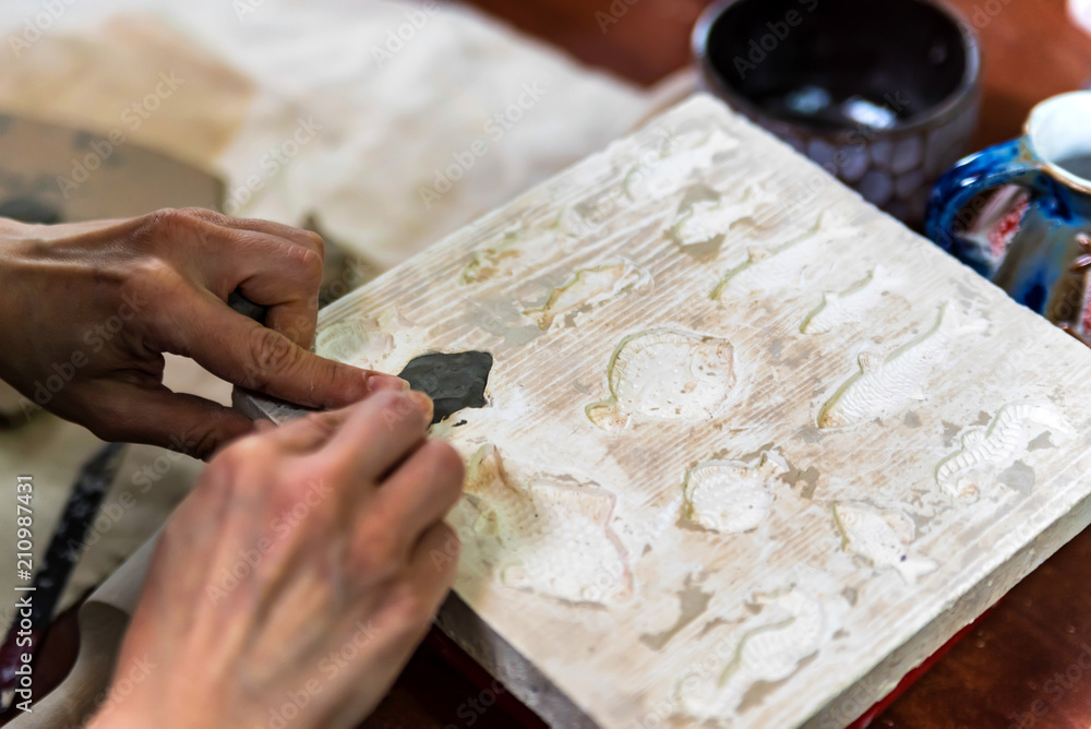Obraz premium Pottery workshop. hands make print on clay