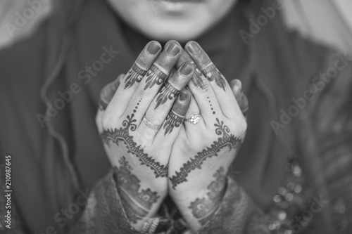 Henna and wedding ring on bride hand, pray for doa session. © nelzajamal