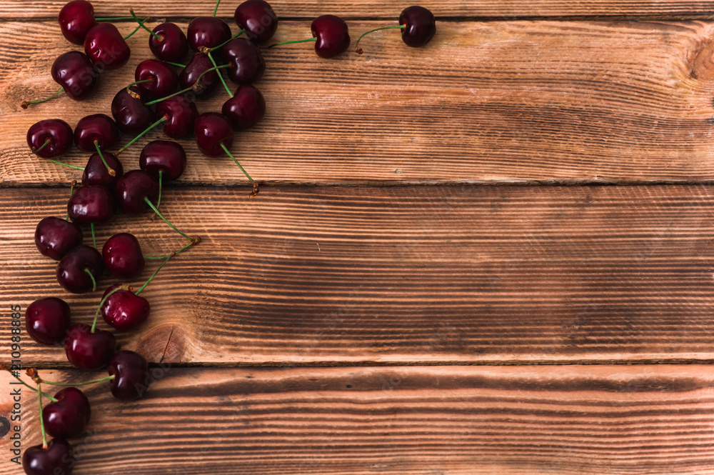 A bunch of cherries on wooden rustic background  with a copy space for text