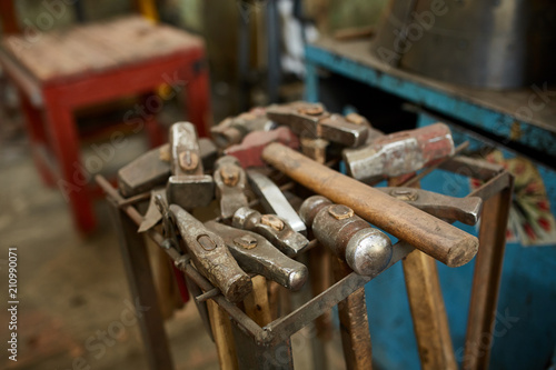 Working metal tools in blacksmith's workshop, close-up, selective focus, nobody