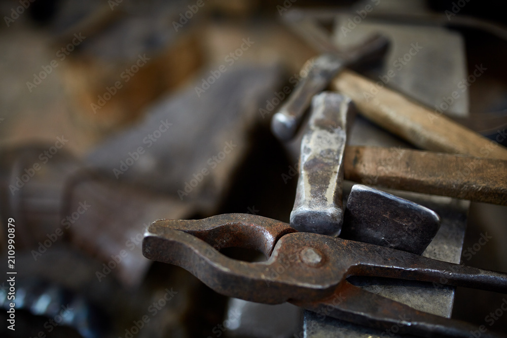 Working metal tools in blacksmith's workshop, close-up, selective focus, nobody Working metal tools in blacksmith's workshop, close-up, selective focus, nobody